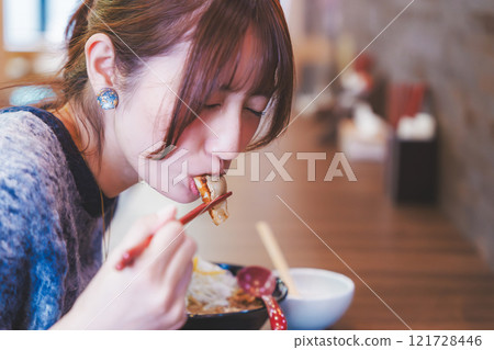 A young woman eating dumplings A young woman eating dumplings 121728446