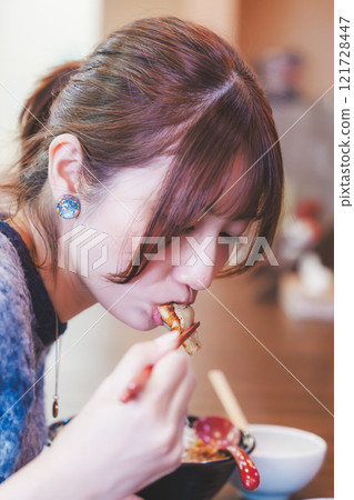 一個年輕女子吃餃子 121728447