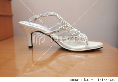 Stylish and highly fashionable woman high heeled shoes with trendy accessories, captured on a colorful background, exuding luxury and elegance perfect for wedding or formal outfit inspiration Stylish and highly fashionable woman high heeled shoes with trendy accessories, captured on a colorful background, exuding luxury and elegance perfect for wedding or formal outfit inspiration 121728580