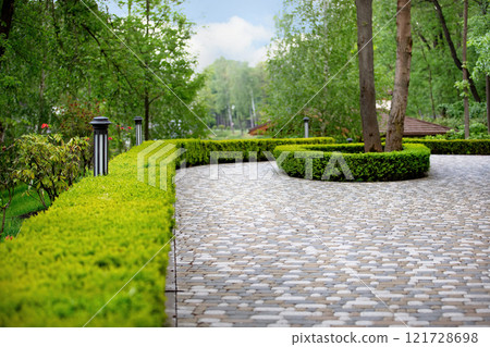 Winding path through lush greenery in a tranquil garden setting Winding path through lush greenery in a tranquil garden setting 121728698