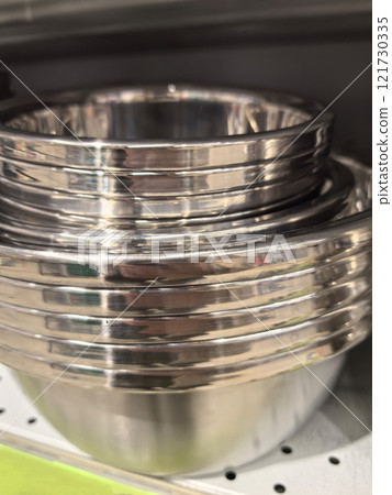 Sleek stainless steel bowls stacked perfectly for kitchen organization 121730335