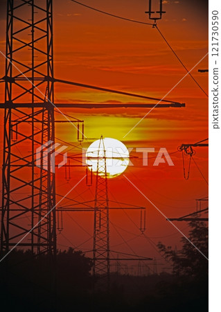 Power transmission towers silhouetted against a sunset sky Power transmission towers silhouetted against a sunset sky 121730590
