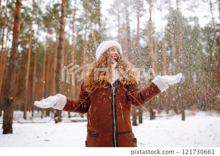 Happy young woman in the winter forest. Christmas, winter holidays concept. 121730661