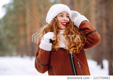 Happy young woman in the winter forest. Christmas, winter holidays concept. 121730662