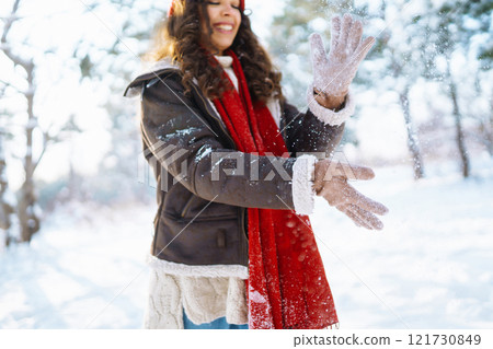 Beautiful Young Smiling woman in her Winter Warm Clothing walking in the snow forest. Beautiful Young Smiling woman in her Winter Warm Clothing walking in the snow forest. 121730849