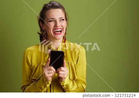 smiling trendy female in green blouse isolated on green 121731214