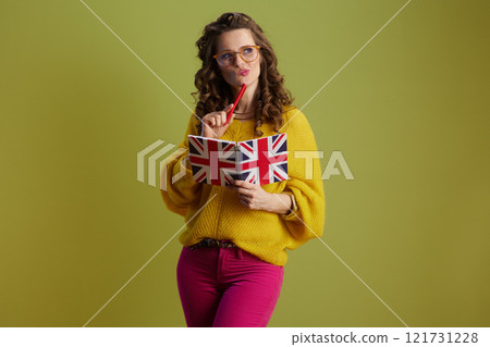 pensive fit woman in sweater and glasses isolated on green pensive fit woman in sweater and glasses isolated on green 121731228