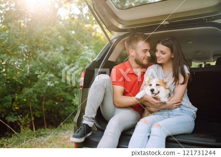 Portrait of caring, loving couple with their dog in back seat of car while traveling. Pet and human. 121731244