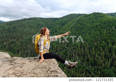Traveler observes mountain scenery from cliff, view of European troll tongue. Concept of freedom. Traveler observes mountain scenery from cliff, view of European troll tongue. Concept of freedom. 121731385