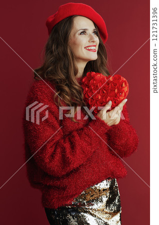 smiling modern female in red sweater and beret with red heart 121731396