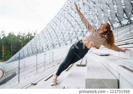 Young woman in sportswear is training outdoors. Sports concept, healthy body. Young woman in sportswear is training outdoors. Sports concept, healthy body. 121731566