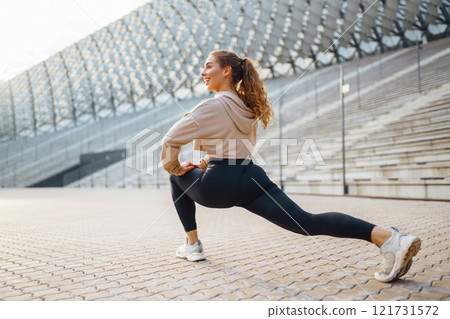 Young woman in sportswear is training outdoors. Sports concept, healthy body. Young woman in sportswear is training outdoors. Sports concept, healthy body. 121731572