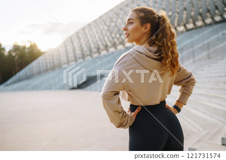 Young woman in sportswear is training outdoors. Sports concept, healthy body. 121731574