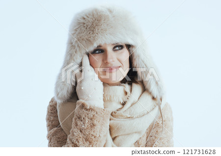 pensive woman in winter coat and fur hat touching face on white pensive woman in winter coat and fur hat touching face on white 121731628