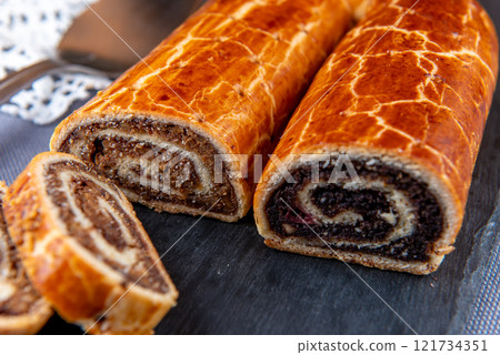 Traditional Hungarian Christmas cookies with poppy seed and walnut on a black cutting board. 121734351