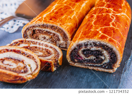 Traditional Hungarian Christmas cookies with poppy seed and walnut on a black cutting board. 121734352