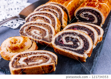 Traditional Hungarian Christmas cookies with poppy seed and walnut on a black cutting board. 121734353