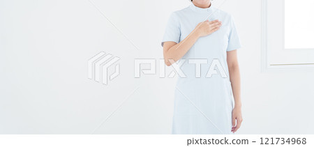 Smiling female nurse putting her hand on her chest 121734968