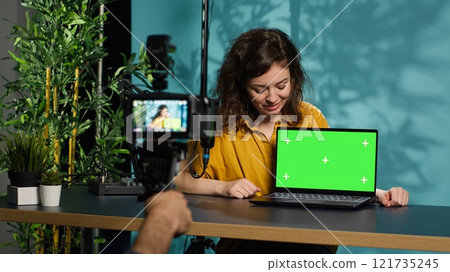 Woman filming herself watching internet videos on mockup laptop requested by viewers. Online influencer reacting to online clips sent by subscribers using green screen notebook, camera A Woman filming herself watching internet videos on mockup laptop requested by viewers. Online influencer reacting to online clips sent by subscribers using green screen notebook, camera A 121735245