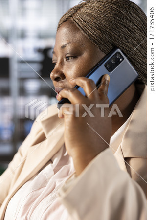 CEO in office talking on phone with partners, ensuring compliance with company policies. Manager in telephone call with shareholders, identifying opportunities for operational cost savings CEO in office talking on phone with partners, ensuring compliance with company policies. Manager in telephone call with shareholders, identifying opportunities for operational cost savings 121735406
