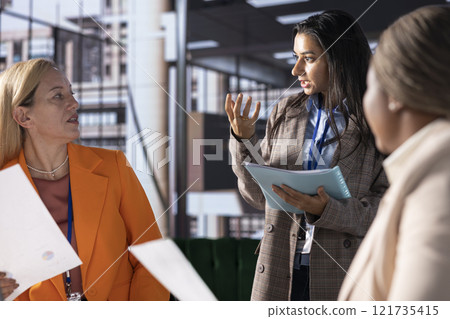 Multiethnic women executives uniting forces in a collaborative meeting, focused on data management and business development. Experts with leadership skills fighting for empowerment. 121735415