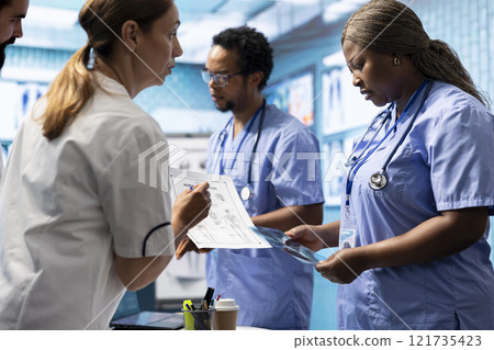 Hospital staff reviews human anatomy and give the correct diagnostic in a medical office meeting. Group of experts ensures accurate treatment service for disease prevention, radiology department. 121735423