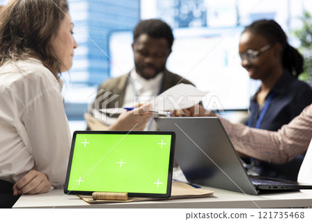 Employees and shareholders using chroma key screen in a corporate briefing, reviewing economic indicators on papers. Business people discussing finance planning and setting strategic goals. Employees and shareholders using chroma key screen in a corporate briefing, reviewing economic indicators on papers. Business people discussing finance planning and setting strategic goals. 121735468
