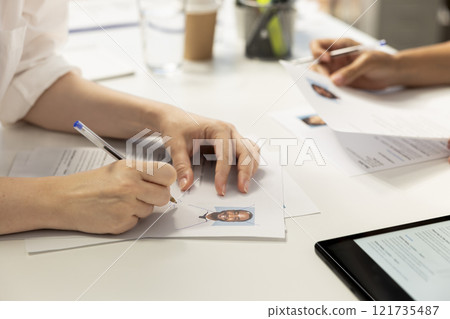HR employee filling in application form after making sure candidate possesses skills needed to fulfil role. HR manager writing signature on documents after evaluating applicant 121735487