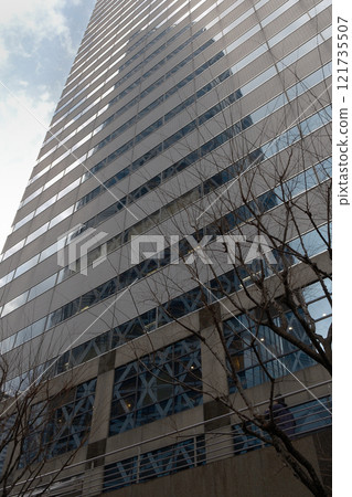 A skyscraper reflected in the mirrored wall of a skyscraper 121735507