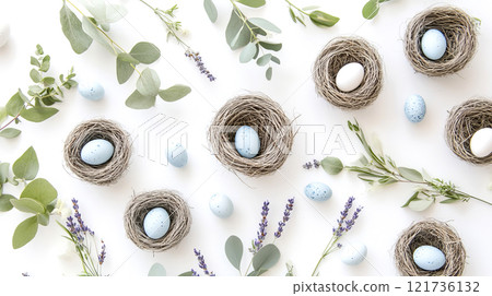 A softly styled arrangement of robin eggs nestled in small nests, framed by eucalyptus leaves and lavender in a serene spring setting 121736132