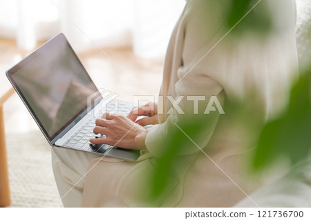一位女士在沙發上用電腦工作 一位女士在沙發上用電腦工作 121736700