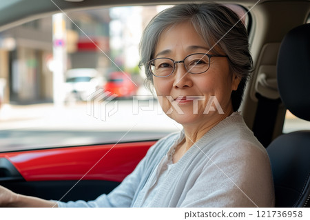 Smiling senior woman in the driver's seat 121736958