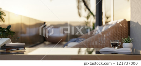 A coffee table features books, a coffee cup, and decorative plants on an apartment balcony. A coffee table features books, a coffee cup, and decorative plants on an apartment balcony. 121737000