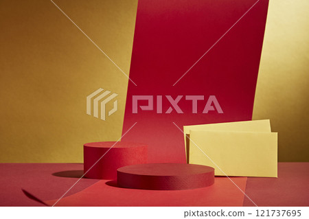Two circular platforms used to showcase products, decorated with red paper strings and yellow fortunate envelopes at a frontal angle. Perfect for a picture of a Lunar New Year on a golden backdrop. 121737695
