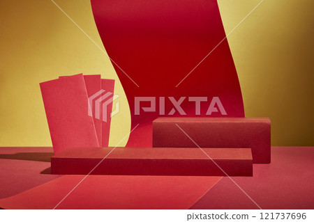 An image of a Lunar New Year picture with a golden backdrop. A frontal angle of red paper strings and lucky envelopes is used to decorate some platforms used to display product promotions. 121737696
