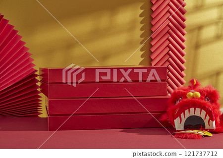 A traditional Chinese New Year theme. A few red rectangular platforms used for displaying products, adorned by a red lion dancing head, red papers, and firecrackers against a golden backdrop. 121737712