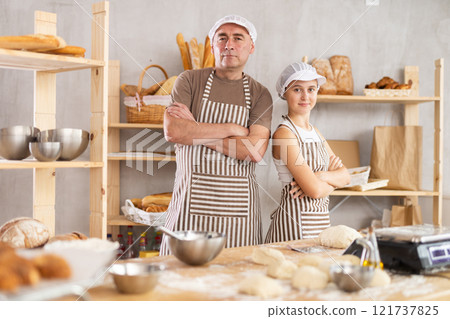 Teenage girl and male baker posing in bakehouse 121737825