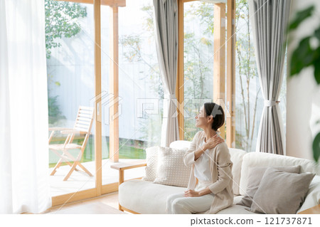 一個女人坐在窗邊接受按摩 一個女人坐在窗邊接受按摩 121737871