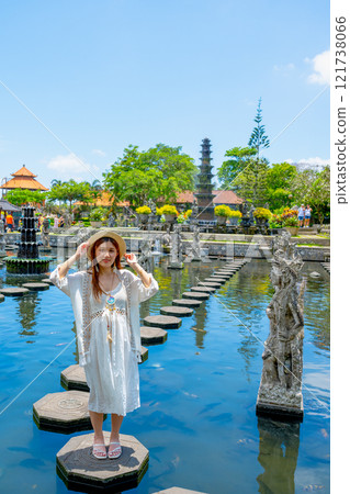 Bali, Indonesia - October 22, 2024: Girl in the pond of Tirta Gangga Water Palace, Bali, Indonesia. 121738066