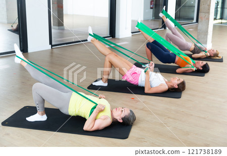 Women doing pilates exercise with expander tape Women doing pilates exercise with expander tape 121738189