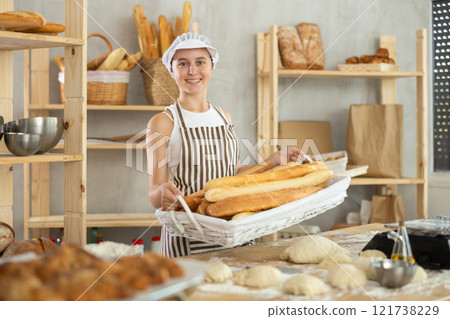 Teen girl holding baguettes in wicker basket Teen girl holding baguettes in wicker basket 121738229