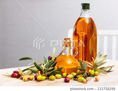 Bottled olive oil and branches with leaves and olives Bottled olive oil and branches with leaves and olives 121738299