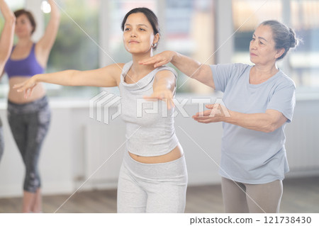 Elderly woman teacher correcting female dancers 121738430