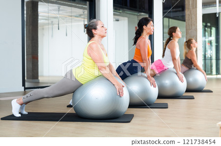 Women during group workout with fitness ball at gym 121738454