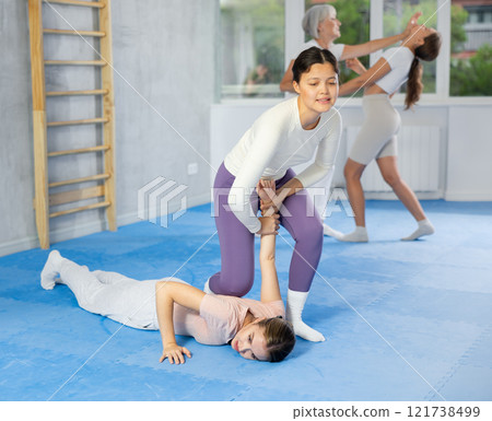 Woman learns to make power grab against female attacker under guidance of trainer. Self-defense class Woman learns to make power grab against female attacker under guidance of trainer. Self-defense class 121738499