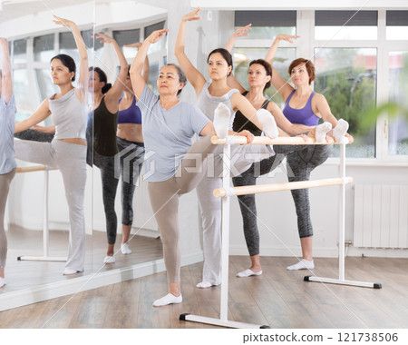 Ballet pose grand batman - women of different ages at choreography lesson 121738506