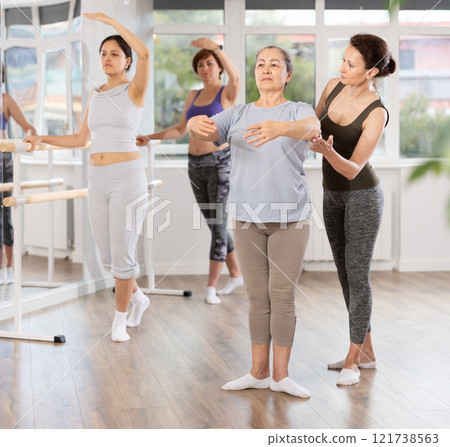 Ballet choreographer instructing senior woman in basic ballet techniques 121738563
