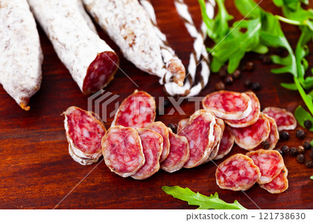 Chopped sausage fuet on wooden table 121738630
