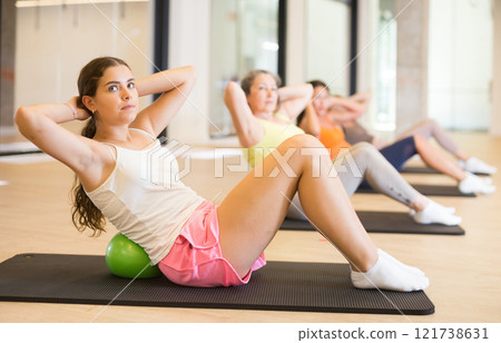 Women doing spine twist with pilates balls Women doing spine twist with pilates balls 121738631