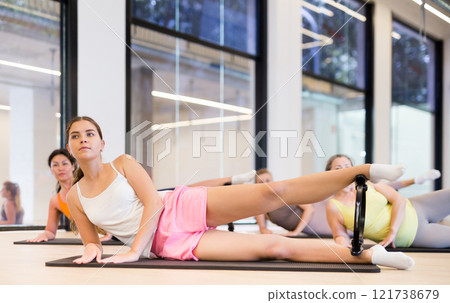 Girl with magic pilates ring doing stretching in fitness center 121738679